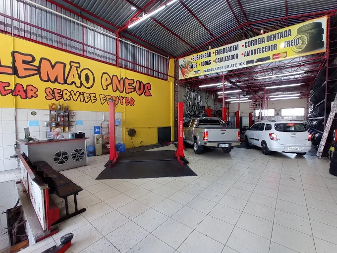 Interior da oficina Alemão Pneus com carros nos elevadores
